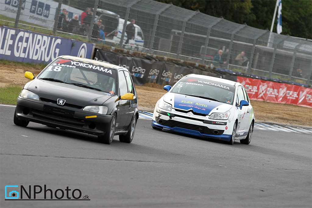 Steffen Larsen (18) i sæsonens 4. bil. Den sorte Peugeot 106 GTI har ikke kørt løb siden 2009, men rusten blev hurtigt kørt af den med podiepladsen i heat 2. Her foran Tue Nielsen (5).
(Foto: CN Photo)